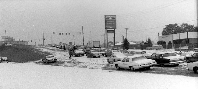 Cars abandoned on an exit ramp on I-285 during Snow Jam 82 with drivers walking up the ramp