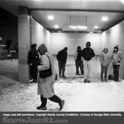 Pedestrians wait under the MARTA Five Points station awning as snow begins to fall - January 12, 1982 – AJC File