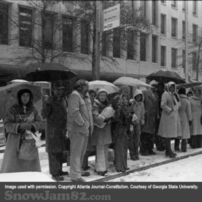Commuters wait for public transportation outside of the Atlanta Journal-Constitution building during a snow storm in downtown Atlanta - January 12, 1982 – Dwight RossJr.)