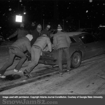 Motorists attempt to push stuck vehicles down an icy road during a snow storm in downtown Atlanta - January 12, 1982 – Kenneth Walker