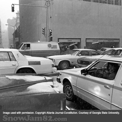 Driver waves from their vehicle from gridlock traffic during a snow storm in downtown Atlanta - January 12, 1982 – Dwight Ross Jr.