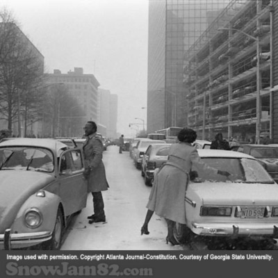 Motorists clear off snow from their windshields as they wait in traffic during a snow storm - January 12, 1982 – Dwight Ross Jr.